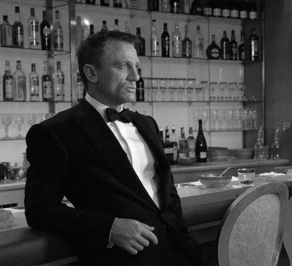 Un homme en smoking, accoudé à un bar